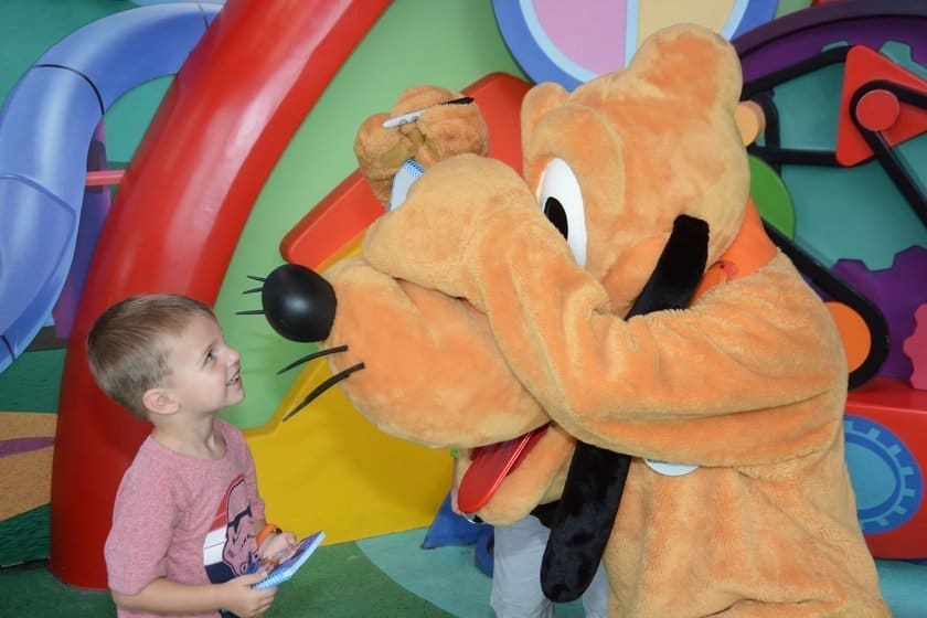 Pluto signing autograph with retractable Sharpie at Disney World